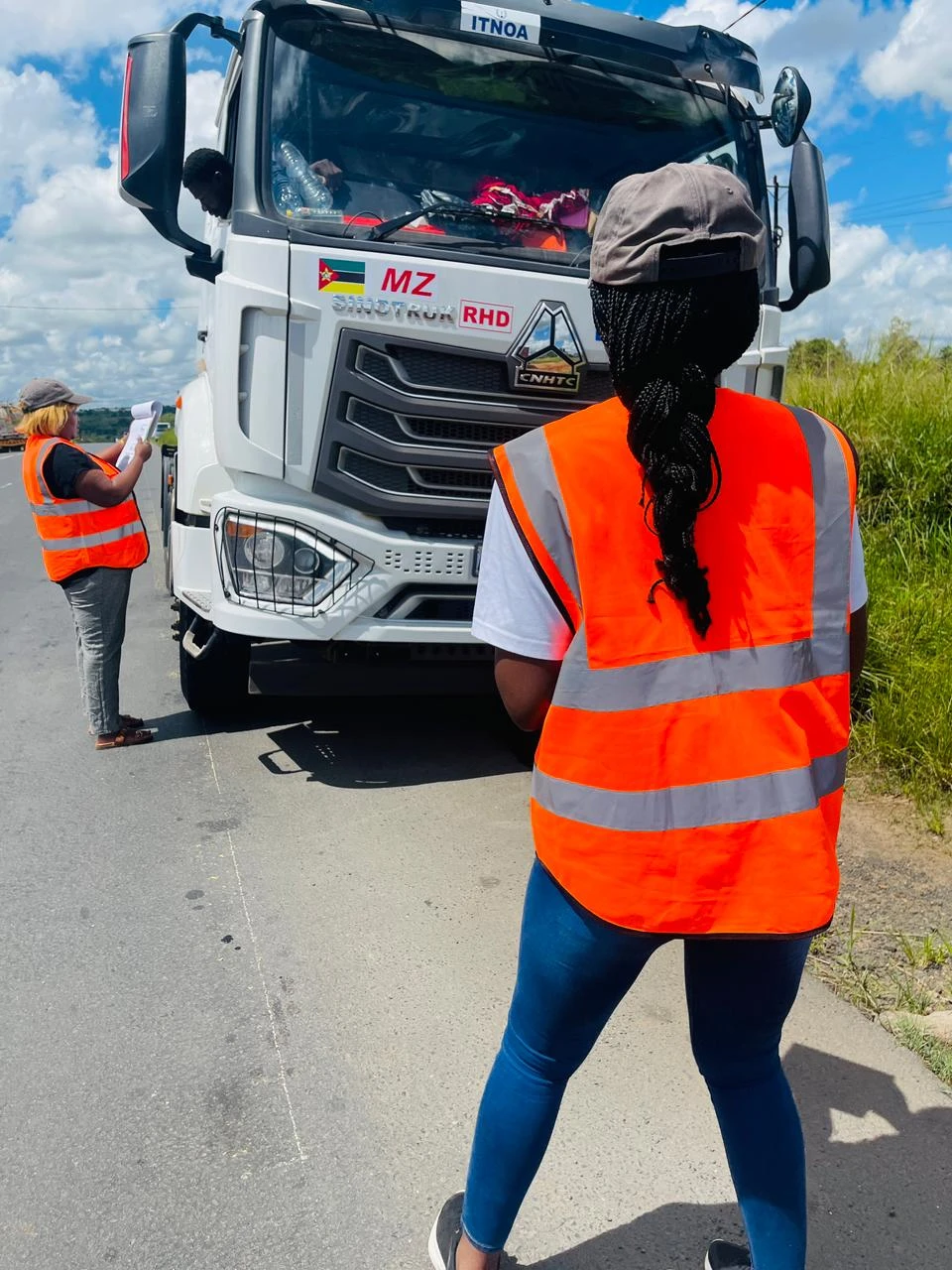 Equipa a realizar inquéritos de campo junto de um veículo de transporte de mercadorias
